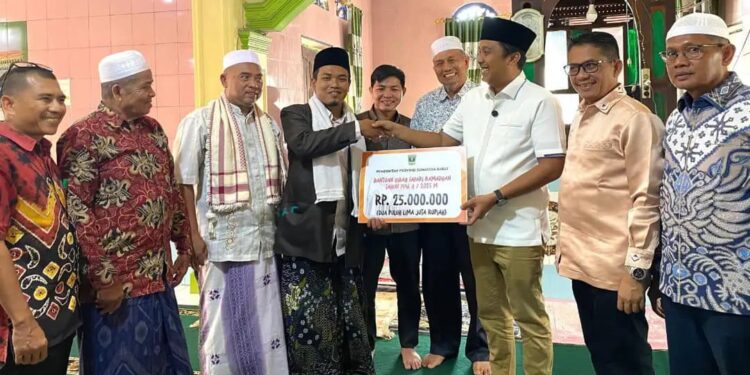 Wagub Sumbar, Vasco Ruseimy saat menyerahkan bantuan uang tunai kepada pengurus Masjid Al-Muttaqin, Jorong Irian, Nagari Ujung Gading. Jumat (14/3) [foto : ist]
