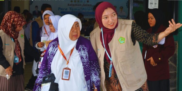 Petugas asrama haji embarkasi Padang saat memberikan pelayanan kepada jemaah Lansia. [foto : ist]