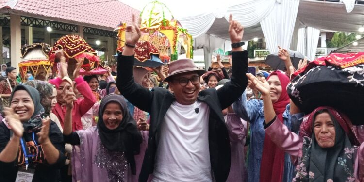 Anggota DPRD Sumbar, Firdaus saat men8kmati keseruan Festival Juadah dengan rombongan arak - arakan. Minggu, (11/05/2025) [foto : sci/yrp]