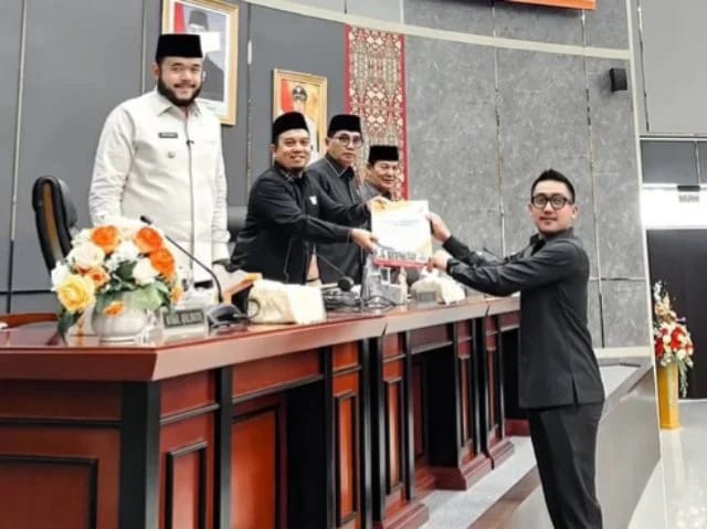 Ketua Komisi II DPRD Kota Padang  Rachmad Wijaya dari Fraksi Partai Gerindra menyerahkan dokumen pada sidang paripurna yang dipimpin   Ketua DPRD Kota Padang Muharlion. [foto : ist]