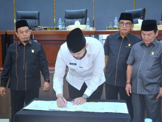 Walikota Padang Fadly Amran menandatangani dokumen yang disepakati  dengan disaksikan pimpinan DPRD Kota Padang. [foto : ist]