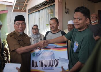 Wakil Wali Kota Padang, Maigus Nasir saat menyerahkan bantuan kepada korban kebakaran di Ganting Parak Gadang.[foto : ist]