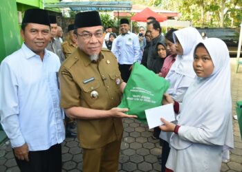 Wakil Wali Kota Padang, Maigus Nasir saat menyerahkan bingkisan kepada anak yatim. [foto : ist]