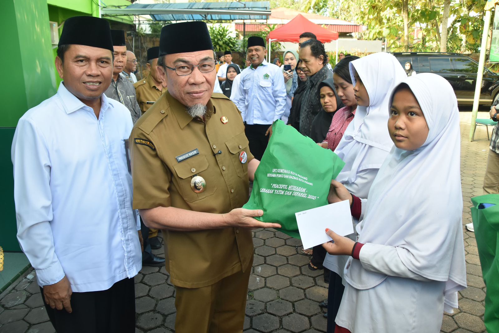 Wakil Wali Kota Padang, Maigus Nasir saat menyerahkan bingkisan kepada anak yatim. [foto : ist]