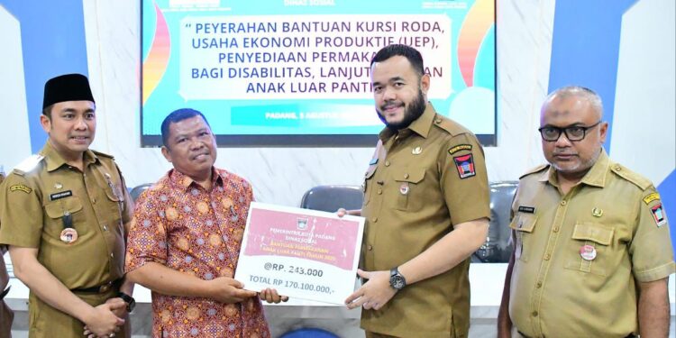 Wali Kota Padang, Fadly Amran saat menyerahkan Bansos.[foto : ist]