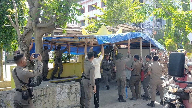 Petugas Satpol PP Kota Padang sedang menertibkan bangunan liar yang digunakan pedagang buat berjualan, Jumat (22/8/2025) (Foto: Ist)