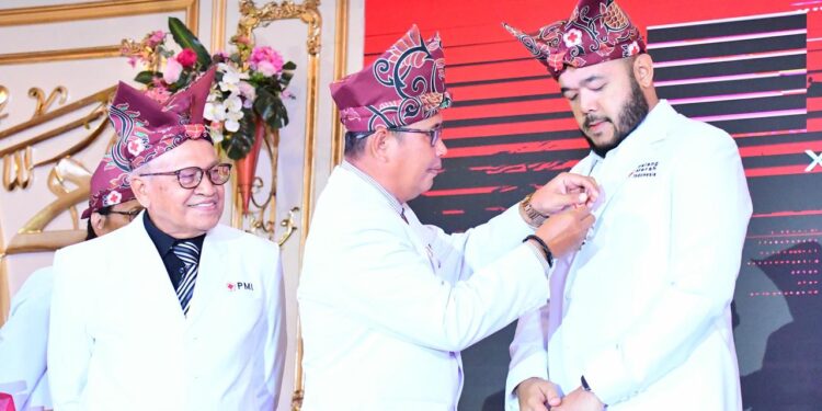 Ketua PMI Kota Padang Zulhardi Zakaria Lathief menyematkan Lencana Jasa Pratama kepada Walikota Padang Fadly Amran, Rabu (17/9). (Foto : Ist)