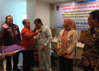 Ketua DPRD Kota Padang Muharlion saat menyematkan kartu peserta bimtek , di jakarta. (Foto: Ist)