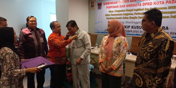 Ketua DPRD Kota Padang Muharlion saat menyematkan kartu peserta bimtek , di jakarta. (Foto: Ist)