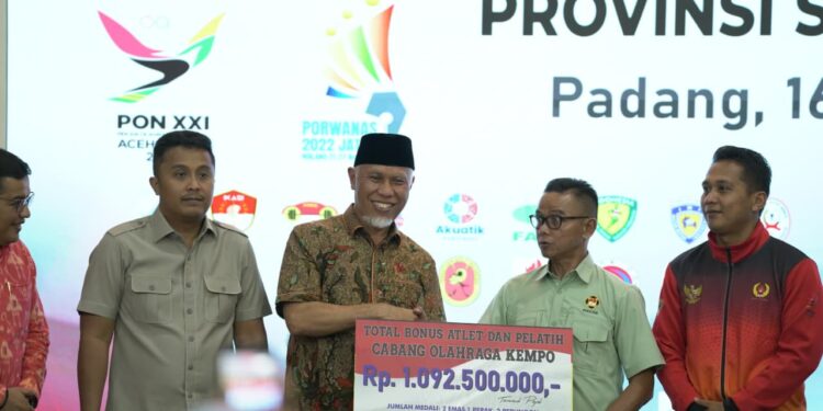 Mahyeldi saat menyerahkan bonus kepada atlet dan pelatih.[foto : ist]