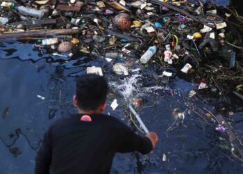 Membersihkan Tumpukan Sampah di Muara Laut