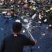 Membersihkan Tumpukan Sampah di Muara Laut