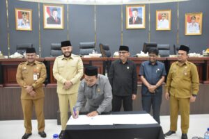 Ketua DPRD Kota Padang Muharlion saat menandatangani laporan sidang